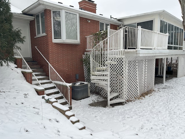 view of snow covered exterior featuring cooling unit