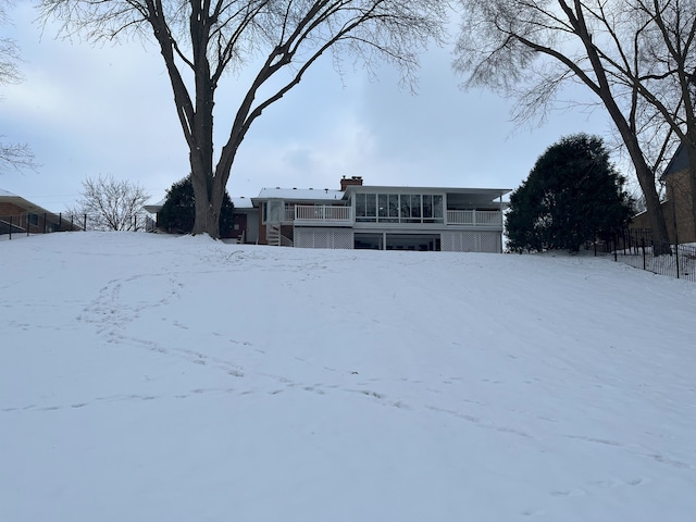 yard covered in snow featuring a sunroom