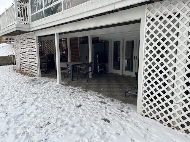 snow covered deck featuring a patio