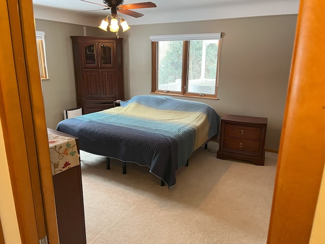 bedroom featuring light carpet and ceiling fan