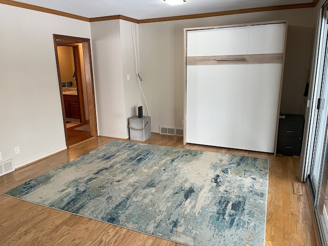 bedroom featuring light wood-type flooring, a closet, and crown molding