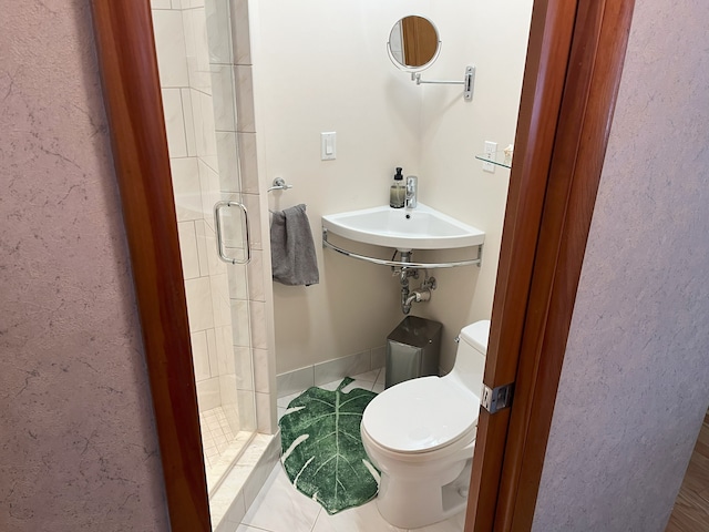 bathroom with toilet, tile patterned floors, a shower with door, and sink