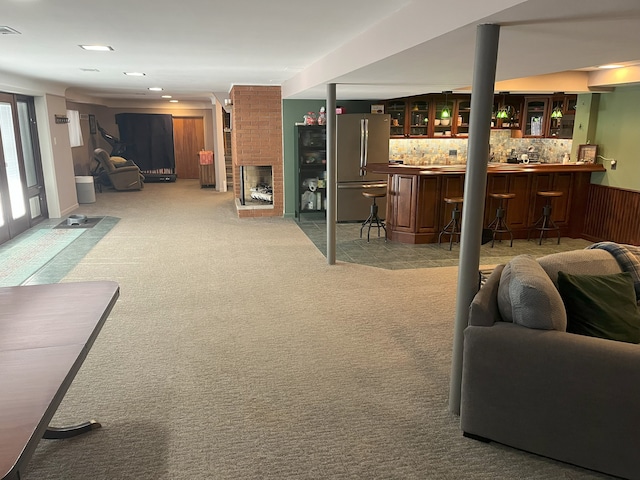 carpeted living room with indoor bar and a fireplace