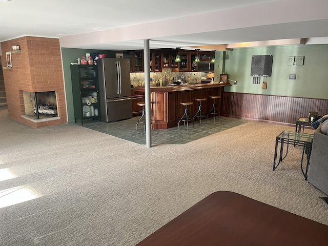 bar with a brick fireplace, stainless steel appliances, and carpet flooring