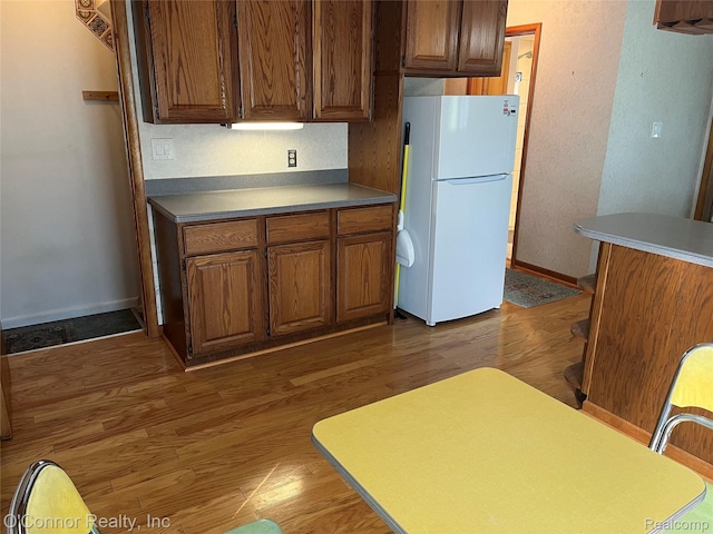 43 W Breitmeyer, Mount Clemens, MI 48043 - kitchen with freestanding refrigerator, wood finished floors, baseboards, and brown cabinets
