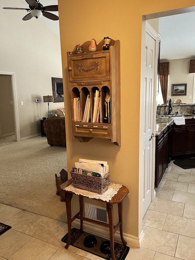 hall featuring sink and light colored carpet