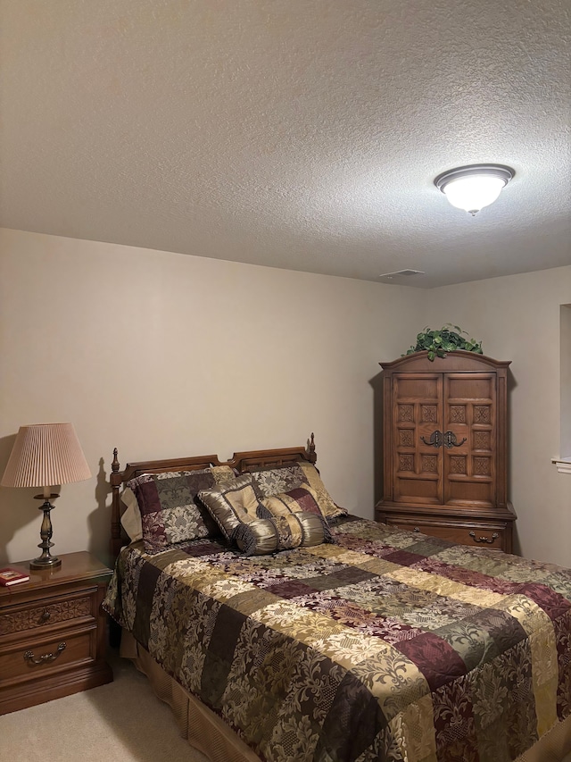 carpeted bedroom with a textured ceiling