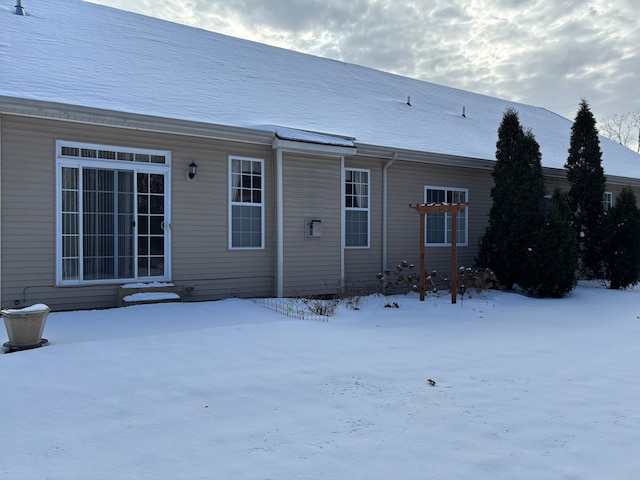 view of snow covered rear of property