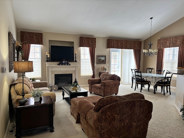 carpeted living room featuring a notable chandelier and vaulted ceiling