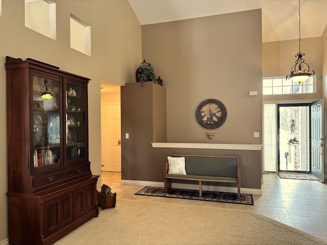 entryway featuring light colored carpet and a high ceiling