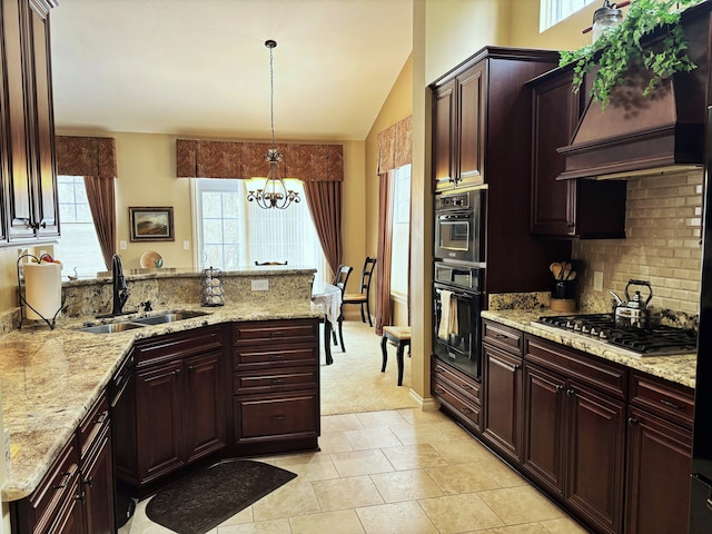 kitchen featuring sink, plenty of natural light, custom range hood, decorative light fixtures, and stainless steel gas stovetop