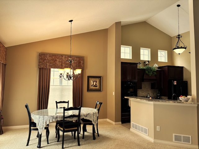 carpeted dining room with vaulted ceiling, plenty of natural light, and a chandelier