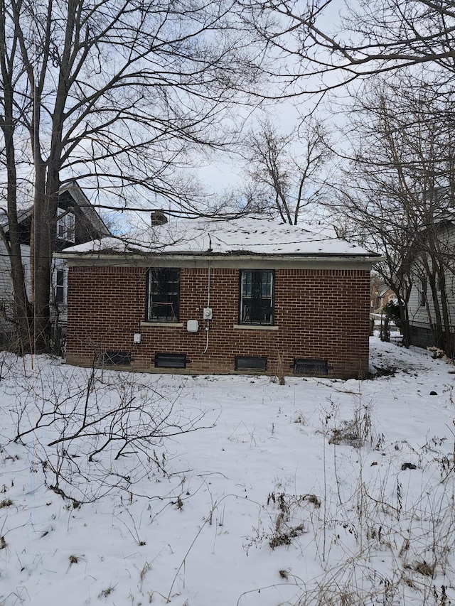 view of snow covered back of property