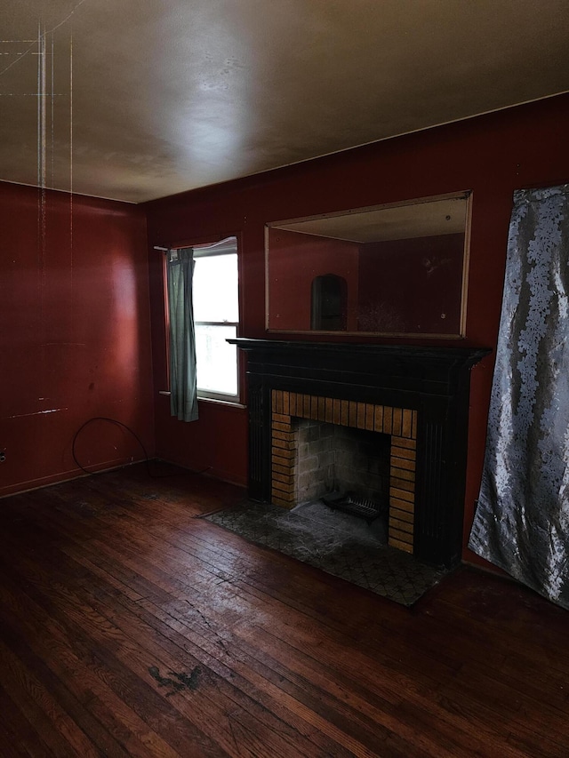 unfurnished living room with dark hardwood / wood-style flooring and a fireplace