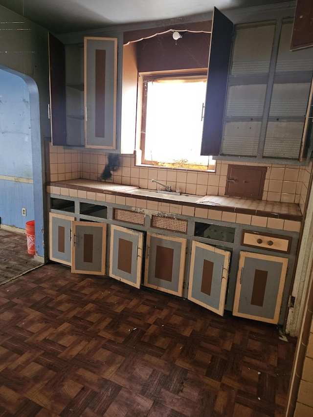 kitchen featuring backsplash, dark parquet flooring, and tile countertops