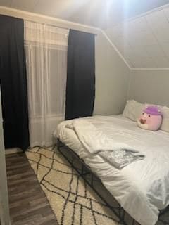 bedroom with vaulted ceiling and hardwood / wood-style flooring