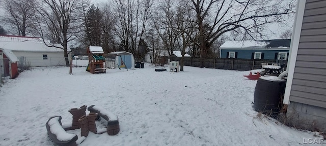 yard covered in snow with a playground