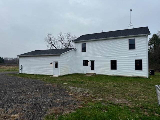 rear view of property featuring a yard