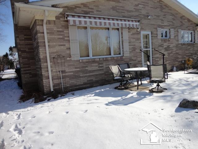 view of snow covered rear of property