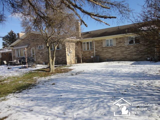 snow covered back of property with central air condition unit