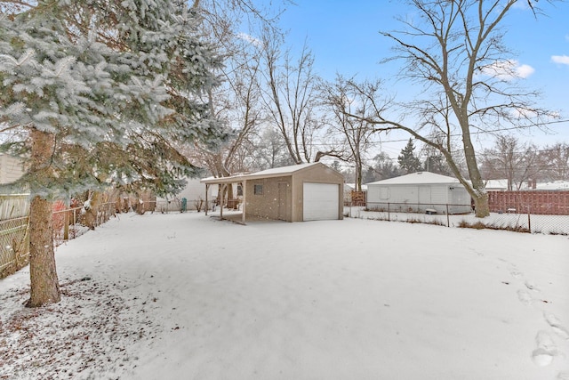 yard covered in snow with a garage and an outdoor structure