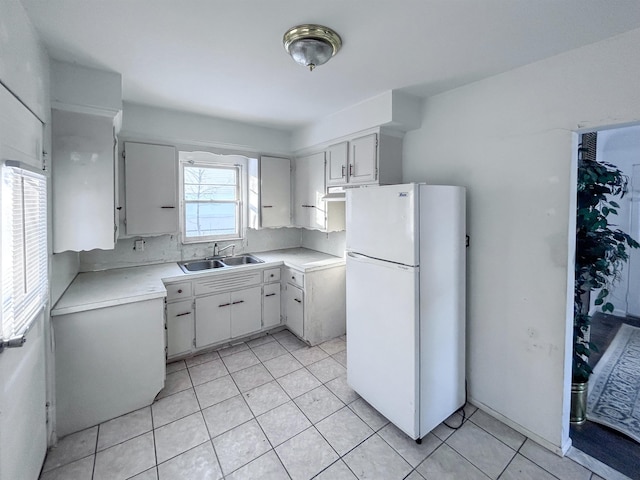 kitchen featuring white refrigerator, a healthy amount of sunlight, white cabinetry, and sink