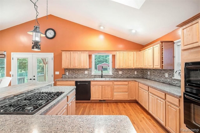 kitchen with lofted ceiling, pendant lighting, light brown cabinets, and black appliances