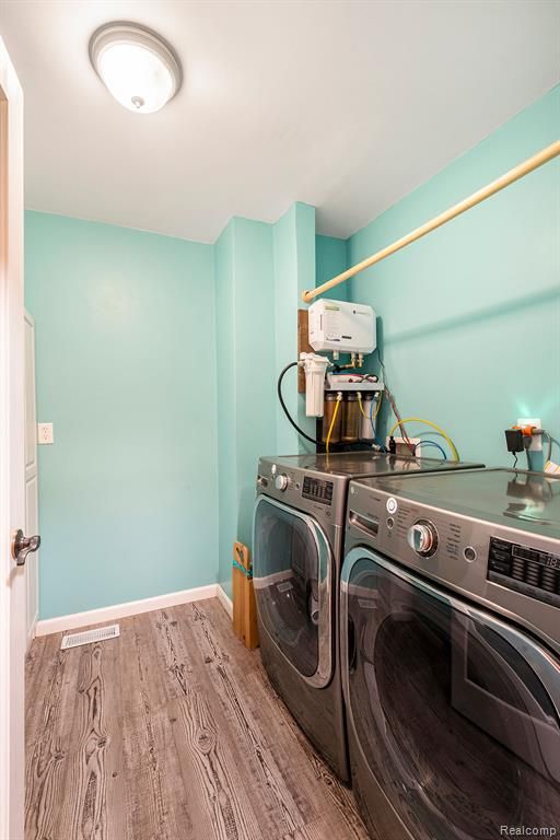 laundry area featuring separate washer and dryer and light hardwood / wood-style flooring