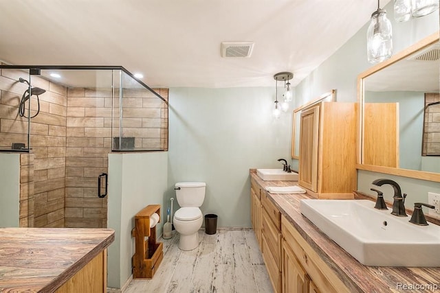 bathroom featuring vanity, toilet, and a shower with door