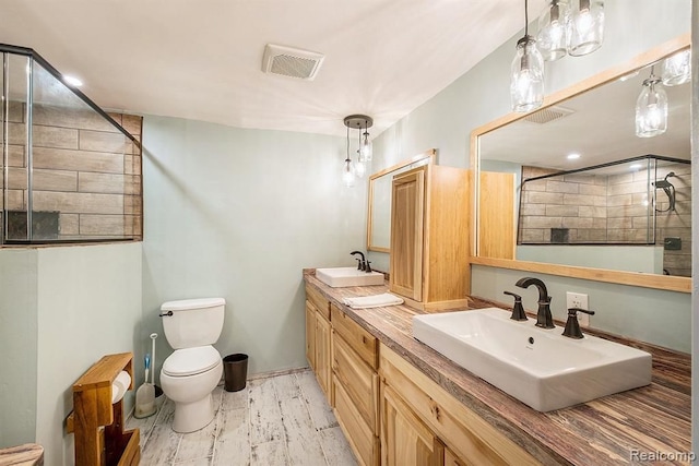 bathroom featuring toilet, vanity, and a tile shower