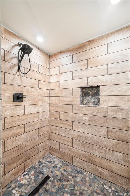 bathroom with walk in shower and wooden walls