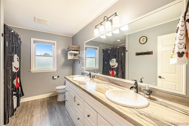 bathroom featuring toilet, ornamental molding, hardwood / wood-style flooring, and vanity