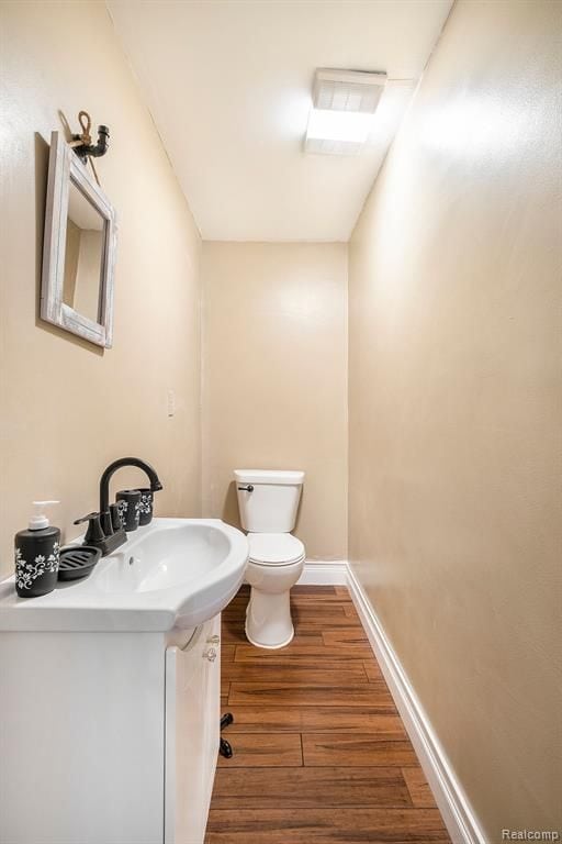 bathroom featuring hardwood / wood-style flooring, toilet, and vanity