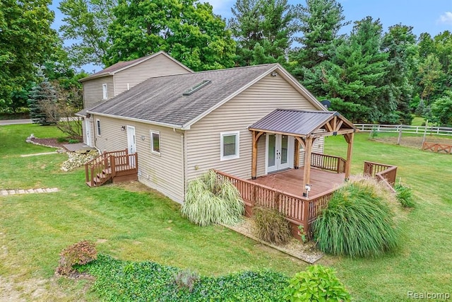 rear view of property featuring a lawn and french doors