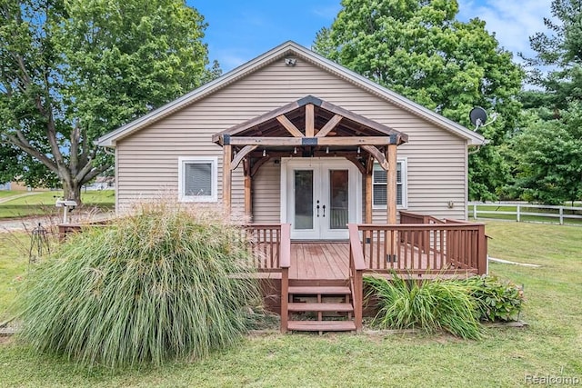 view of front facade featuring a front yard, a wooden deck, and french doors