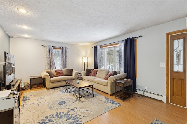 living room featuring a baseboard heating unit, a textured ceiling, and wood-type flooring