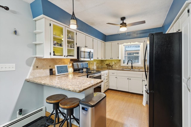 kitchen with kitchen peninsula, a baseboard heating unit, stainless steel appliances, pendant lighting, and sink