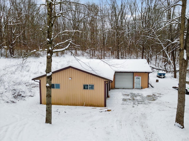 snow covered structure featuring a garage