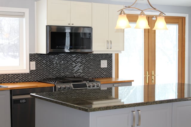 kitchen featuring hanging light fixtures, decorative backsplash, and white cabinetry