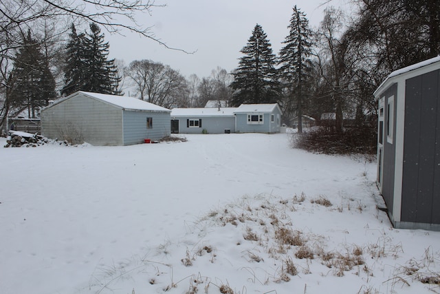 snow covered back of property with a shed