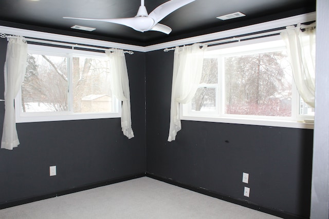 unfurnished room with ceiling fan, carpet flooring, and a healthy amount of sunlight