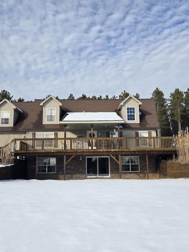 snow covered rear of property featuring a wooden deck