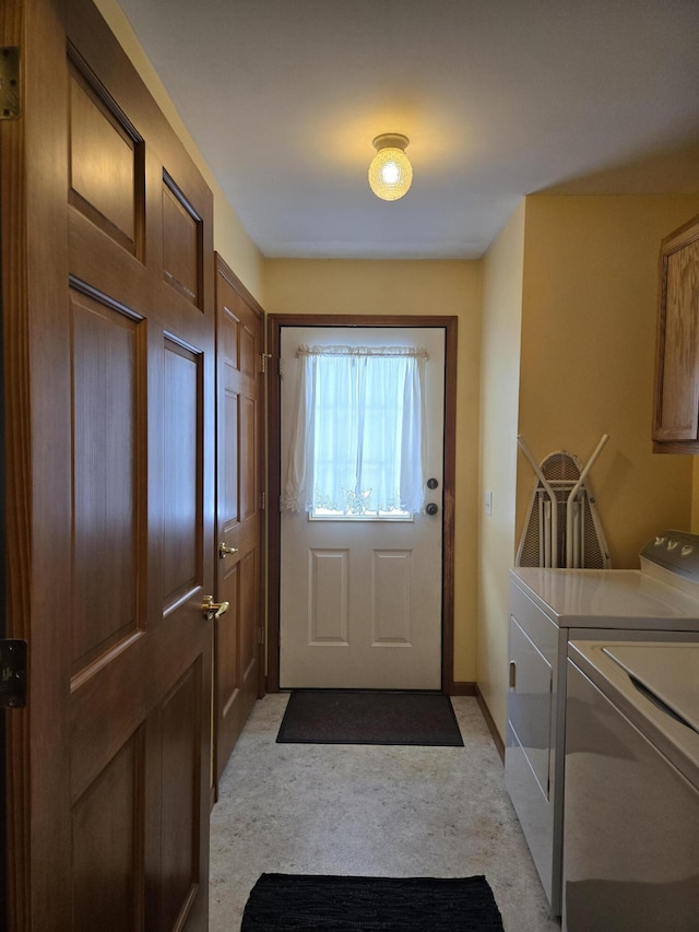 doorway to outside featuring separate washer and dryer and light carpet