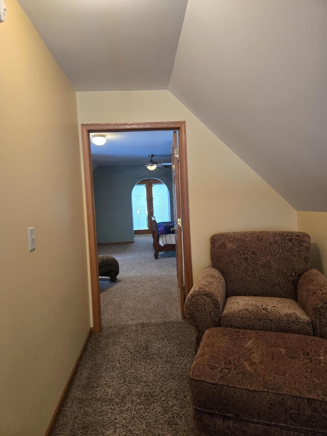 hall with carpet floors and vaulted ceiling