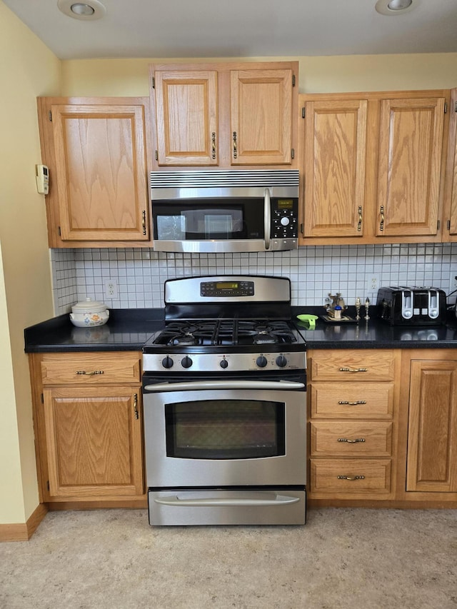 kitchen featuring light brown cabinetry, decorative backsplash, and stainless steel appliances