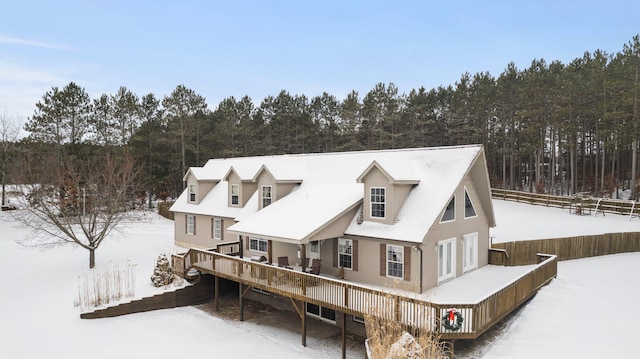 snow covered house with a wooden deck