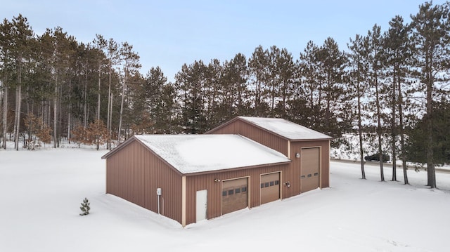 snow covered structure with a garage