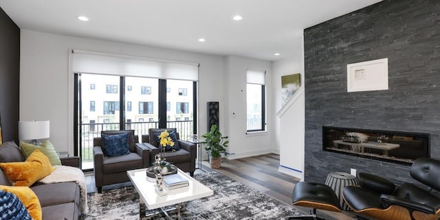 living room with hardwood / wood-style floors and a large fireplace