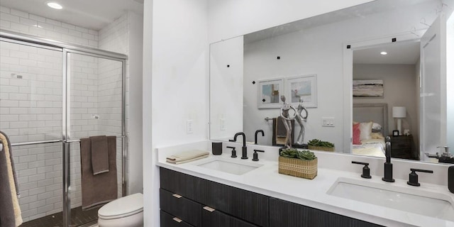 bathroom featuring a shower with door, toilet, and vanity