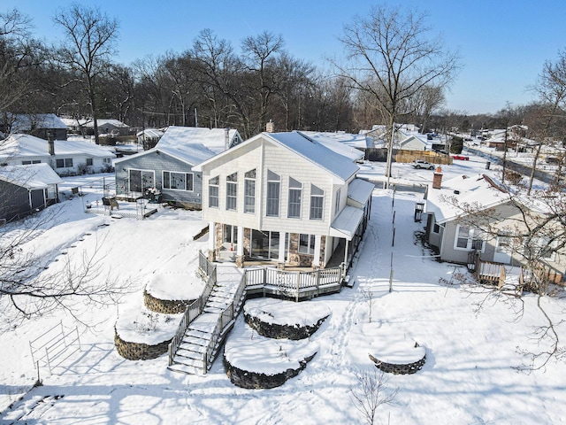 snow covered house featuring a wooden deck